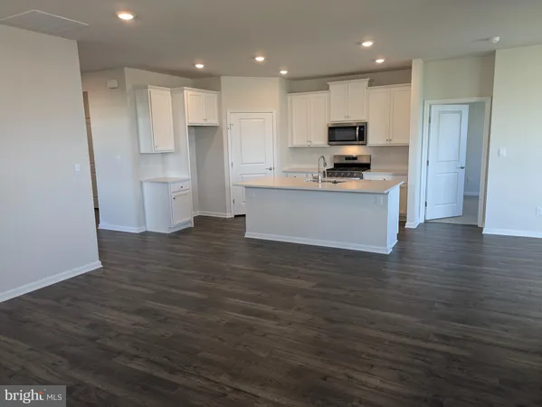 a kitchen with stainless steel appliances granite countertop a refrigerator sink and white cabinets