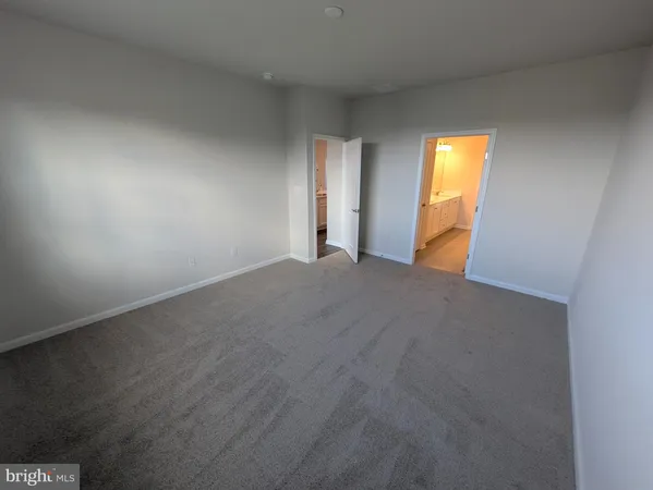 a living room with stainless steel appliances furniture wooden floor and a kitchen view