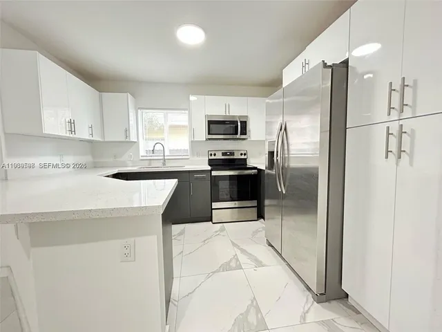 a kitchen with stainless steel appliances granite countertop a refrigerator sink and stove