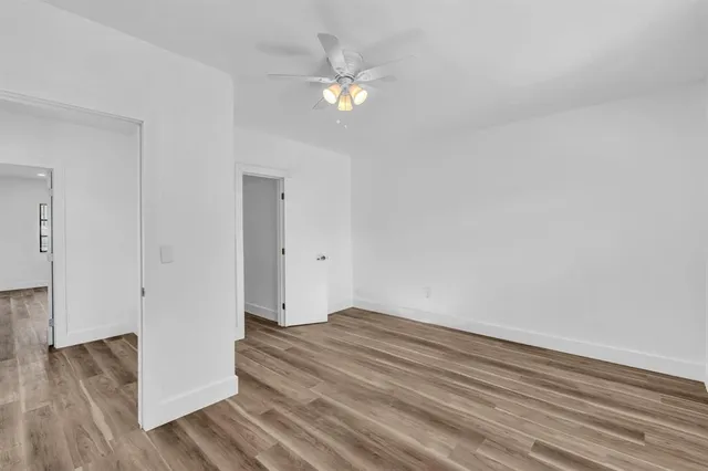 a view of a room with wooden floor and fan