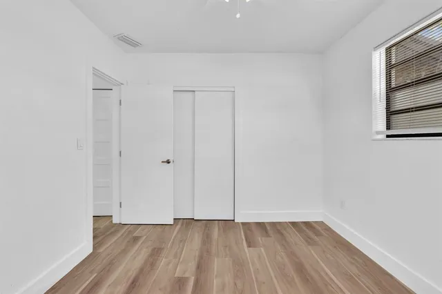 a view of empty room with wooden floor