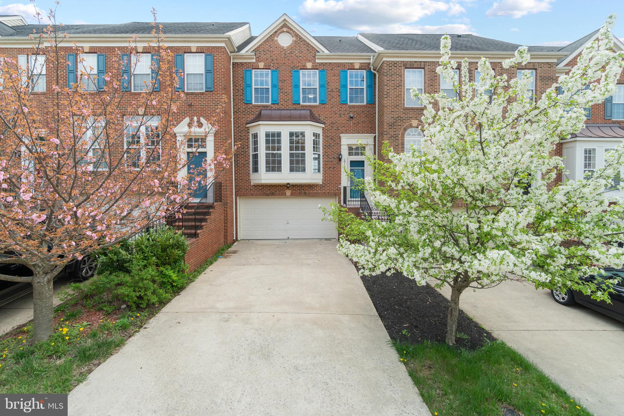 a front view of a house with a yard and potted plants