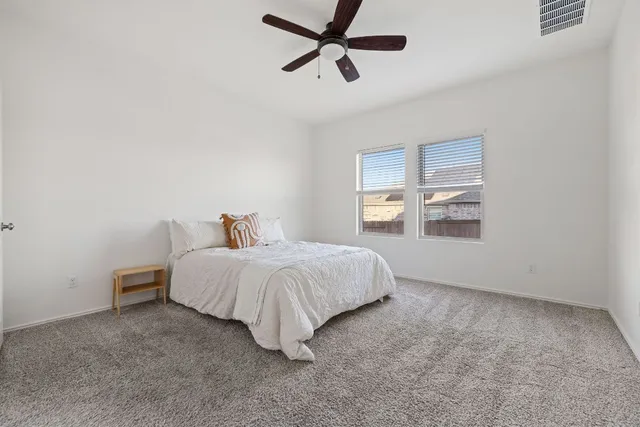 a spacious bedroom with a bed and a window