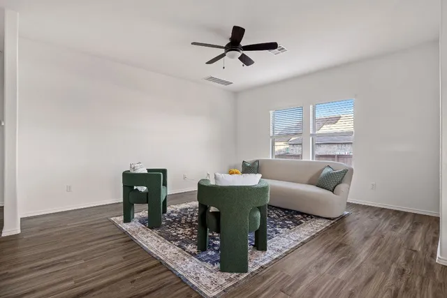 a living room with furniture and a wooden floor