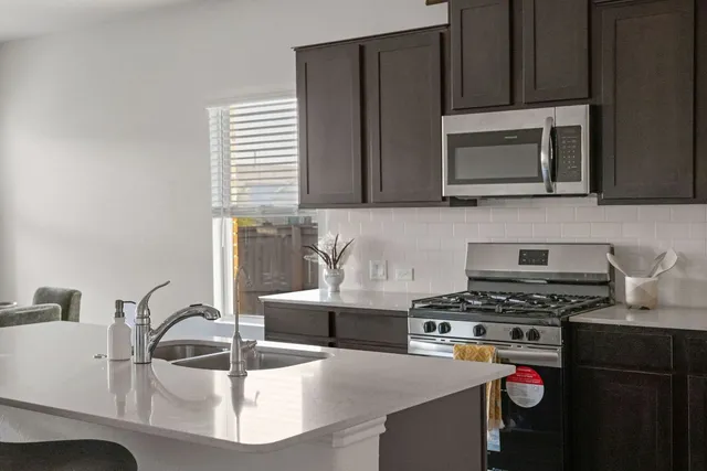 a kitchen with a sink a stove and cabinets