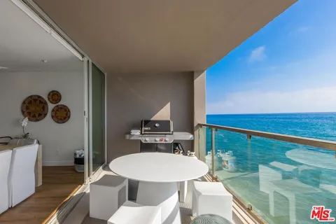 a view of a balcony with a table and chairs
