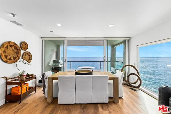 a kitchen with stainless steel appliances kitchen island granite countertop a sink a stove and a wooden floors