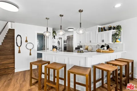 a living room with furniture and a dining table with wooden floor