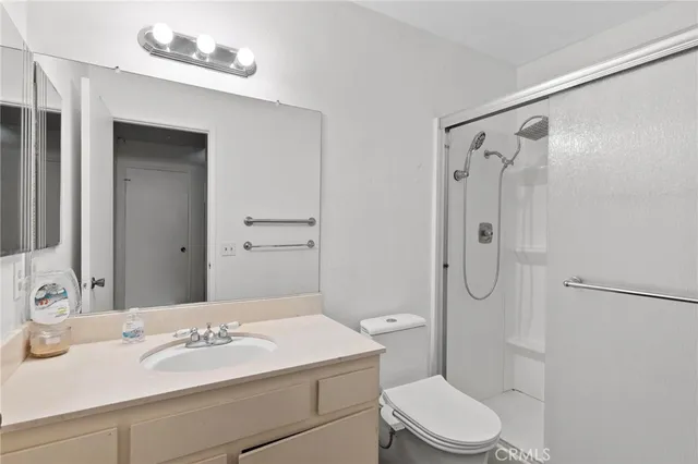a bathroom with a sink toilet mirror and shower