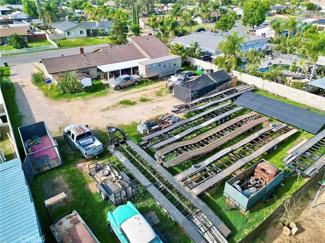 an aerial view of a tennis ground and a cars park side of the road