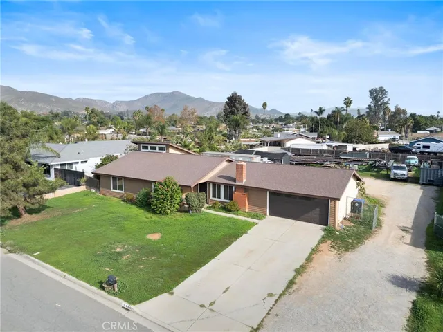 an aerial view of residential houses with outdoor space and trees