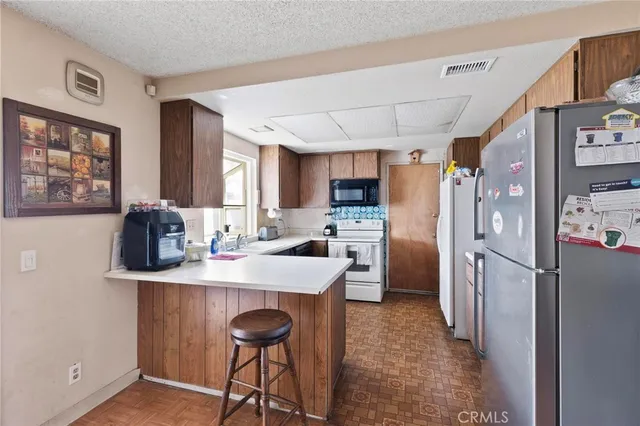 a kitchen with stainless steel appliances a stove refrigerator sink and cabinets
