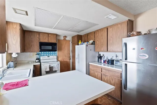 a kitchen with stainless steel appliances a stove refrigerator sink and oven
