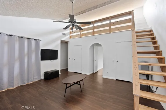 a view of a livingroom with wooden floor and a ceiling fan