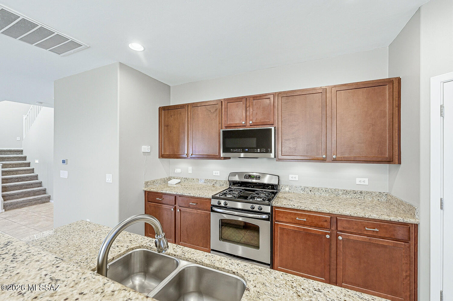 323 East Refuge Loop Vail, AZ 85641 - Photo 11 of 51 a kitchen with granite countertop a stove sink and cabinets