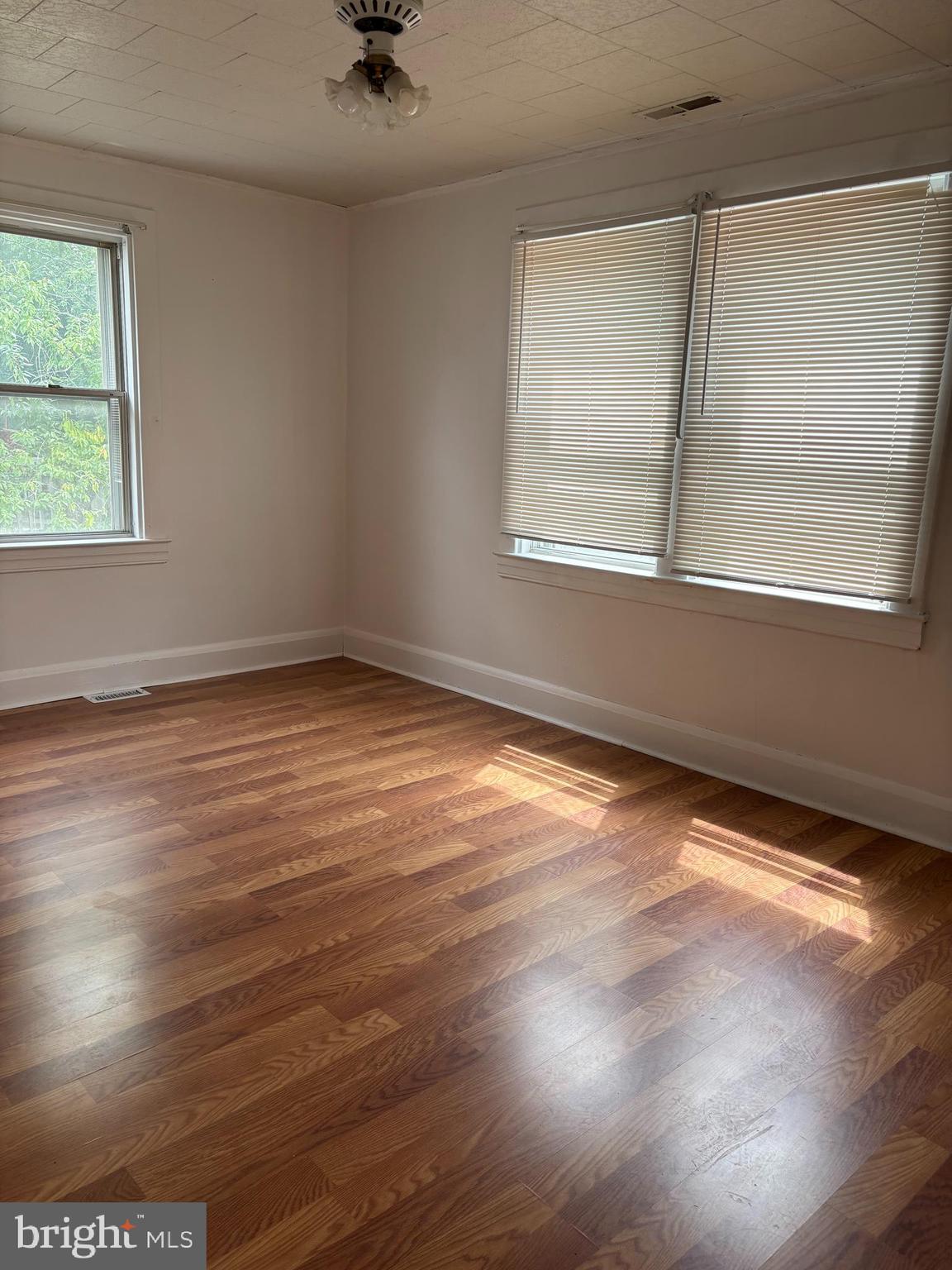 3015 Chesley Avenue Baltimore, MD 21234 - Photo 5 of 30 an empty room with wooden floor and windows