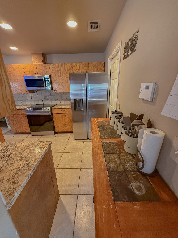 500 Jim Hogg Road Georgetown, TX 78633 - Photo 19 of 37 Kitchen with decorative backsplash, stainless steel appliances, light tile patterned flooring, and recessed lighting