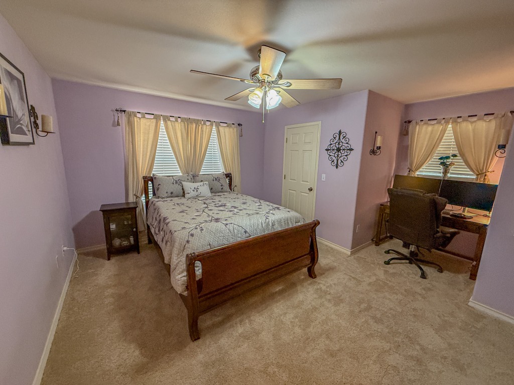 500 Jim Hogg Road Georgetown, TX 78633 - Photo 25 of 37 Bedroom featuring light carpet, a ceiling fan, multiple windows, and an office area
