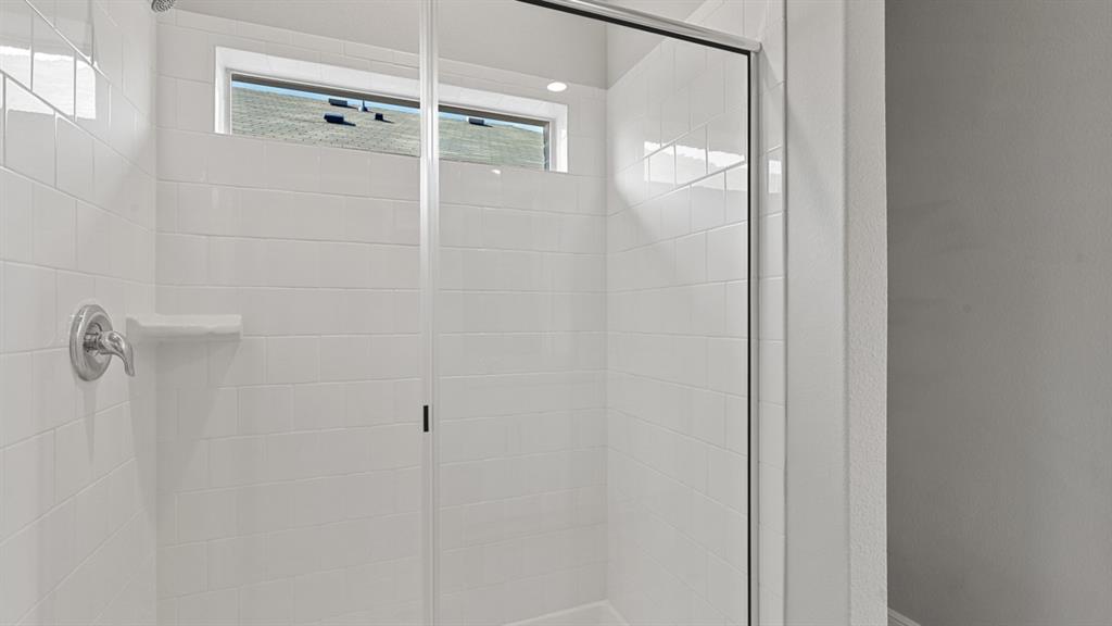 16421 Rangerville Drive Justin, TX 76247 - Photo 18 of 40 a bathroom with a glass shower door