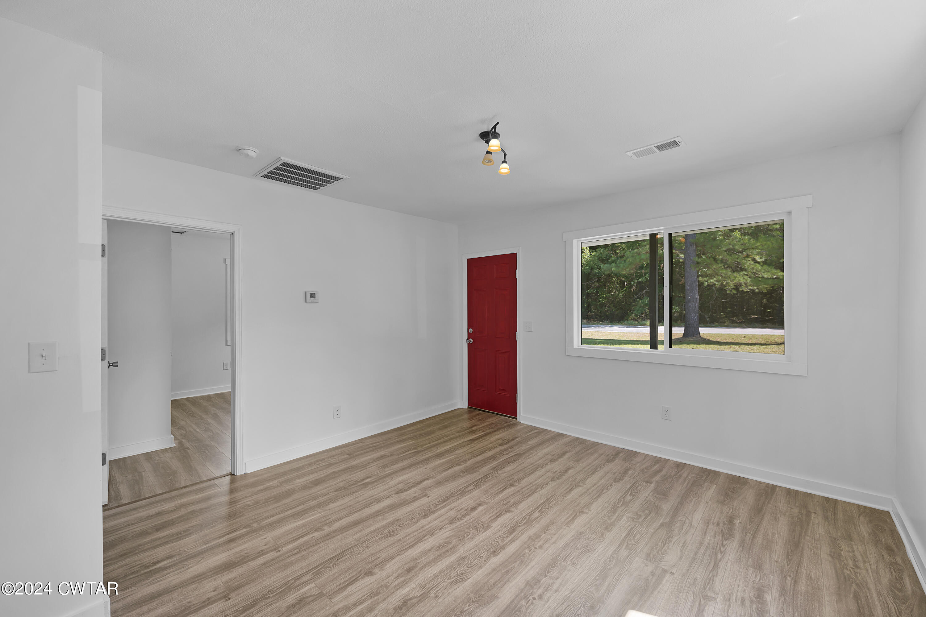 94 McAbee Road Jackson, TN 38301 - Photo 5 of 19 a view of an empty room with wooden floor and a window