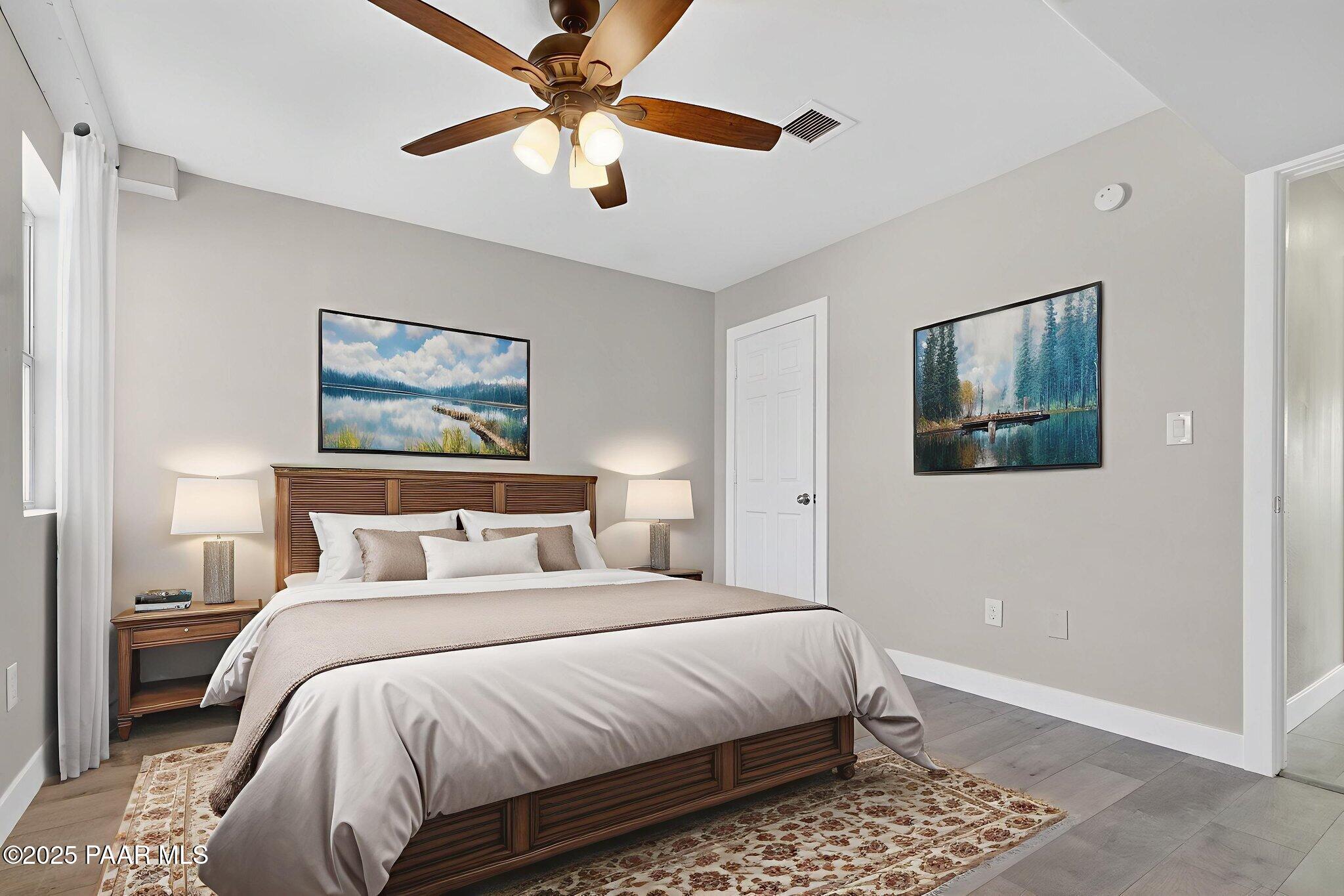14410 East Blue Ridge Road Dewey-Humboldt, AZ 86327 - Photo 26 of 60 a bedroom with bed and a chandelier