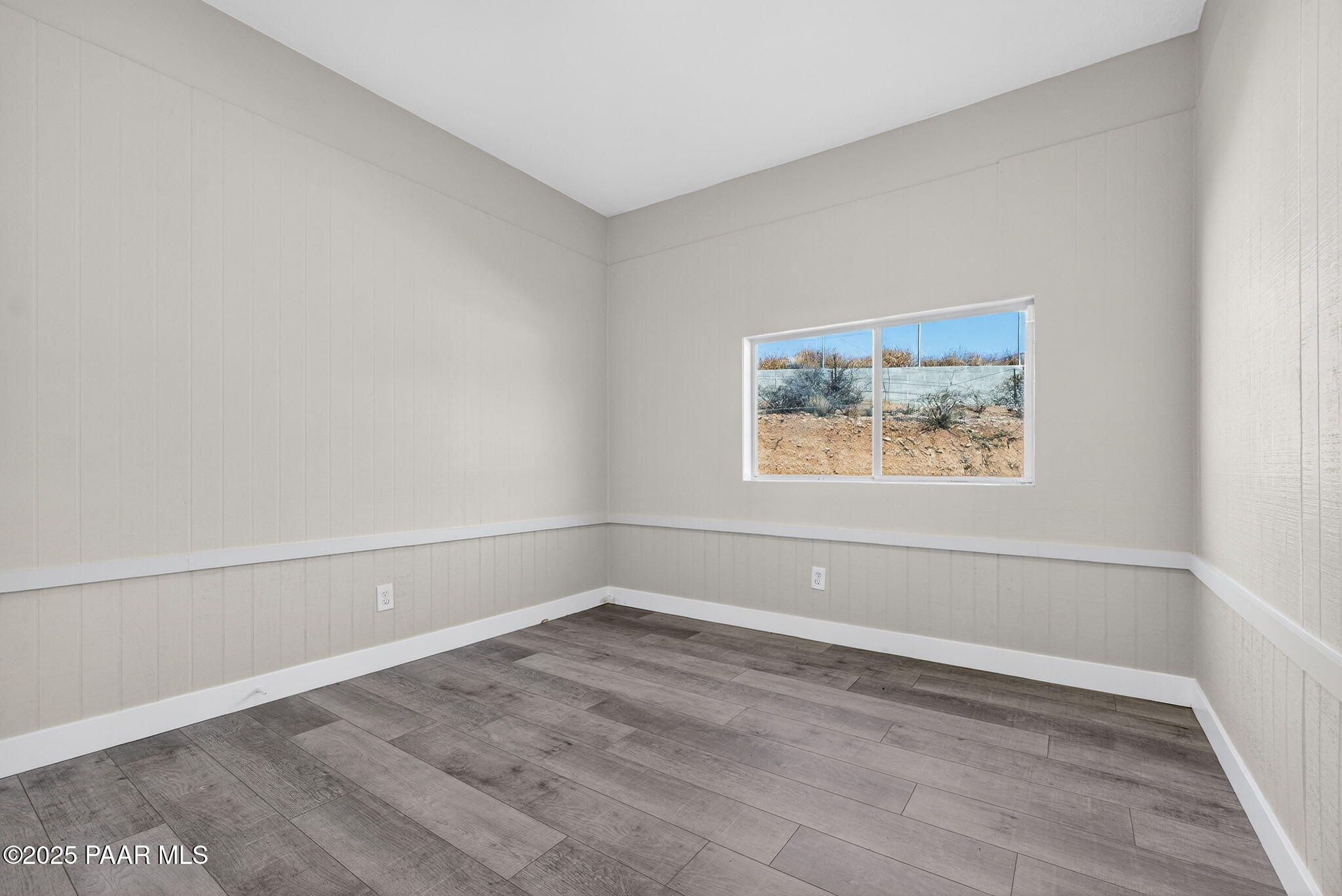 14410 East Blue Ridge Road Dewey-Humboldt, AZ 86327 - Photo 31 of 60 an empty room with wooden floor and window