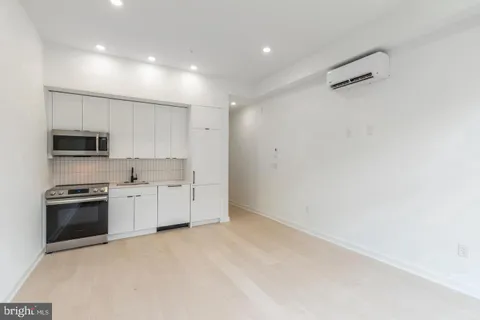 a kitchen with stainless steel appliances a refrigerator a stove top oven a sink and cabinets