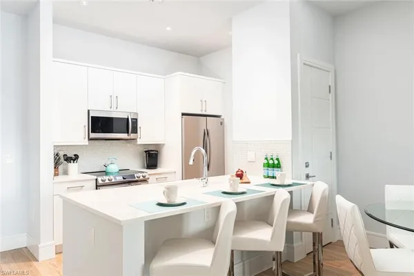 a dining room with furniture and a kitchen view