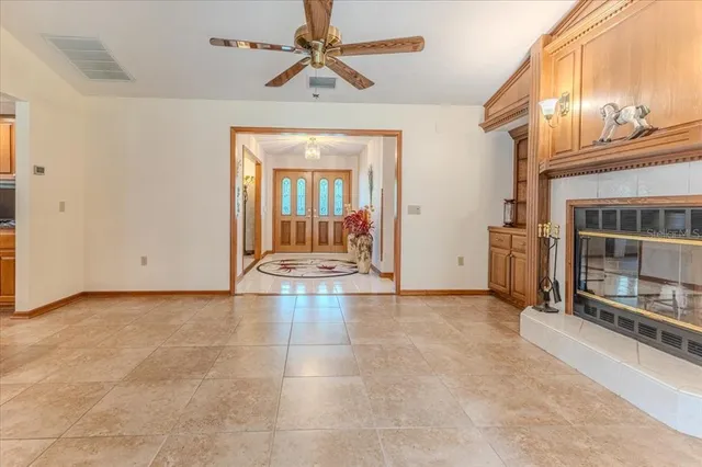 a spacious bedroom with a bed a dresser and a chandelier