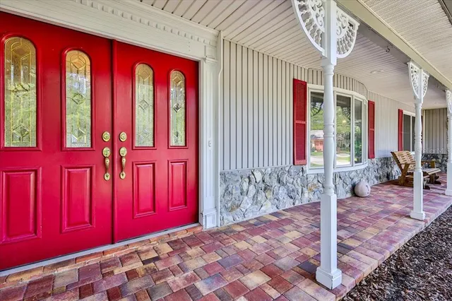 a front view of a house with a yard and potted plants