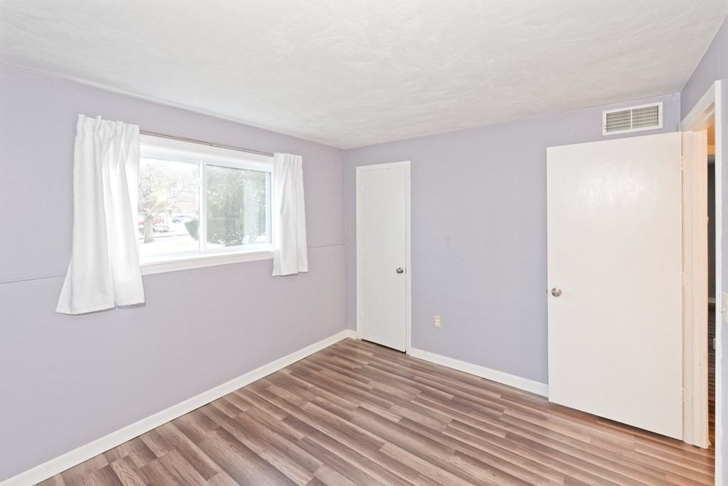 176 Maple Avenue, Unit 27 Rutland, MA 01543 - Photo 13 of 19 a view of an empty room with wooden floor and a window