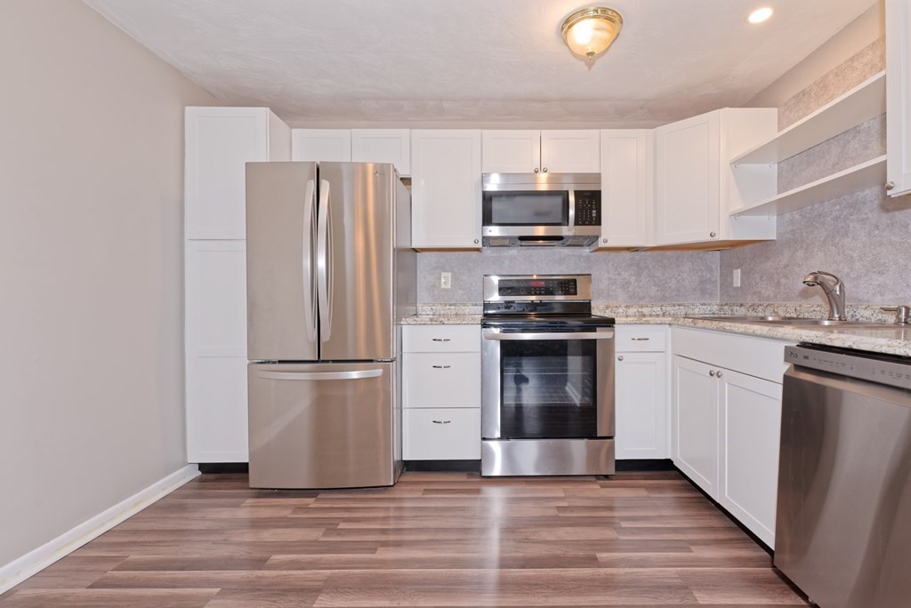 176 Maple Avenue, Unit 27 Rutland, MA 01543 - Photo 4 of 19 a kitchen with stainless steel appliances a refrigerator stove and microwave