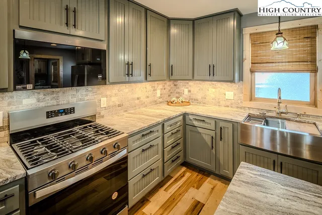 a kitchen with a sink stove top oven and cabinets