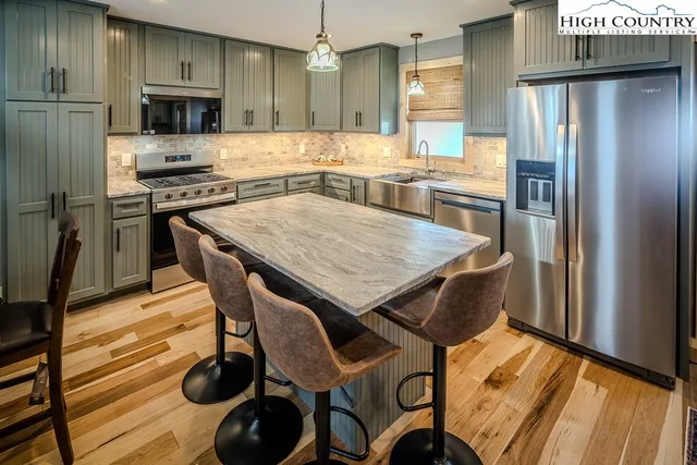 a kitchen with stainless steel appliances granite countertop a stove refrigerator and microwave