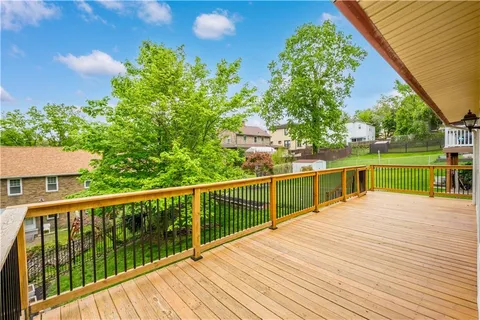 a view of a balcony with wooden floor and fence