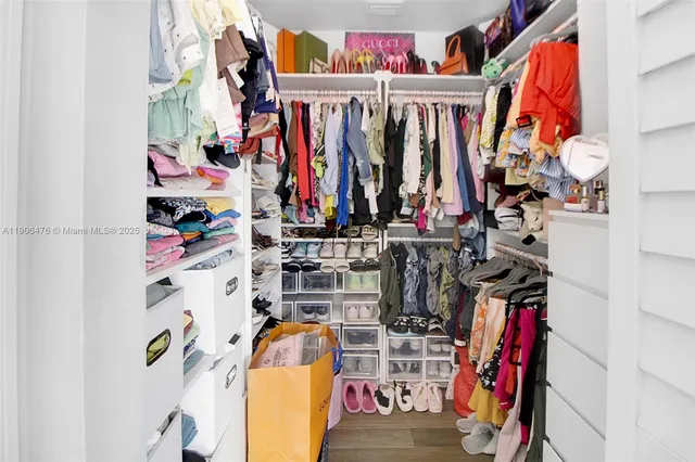 a view of walk in closet with clothes