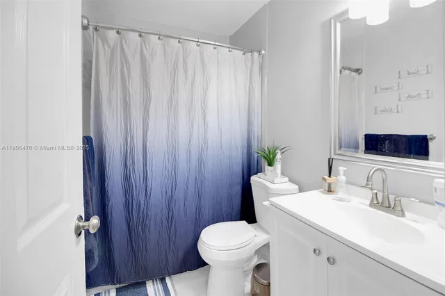a bathroom with a sink a toilet and shower curtain