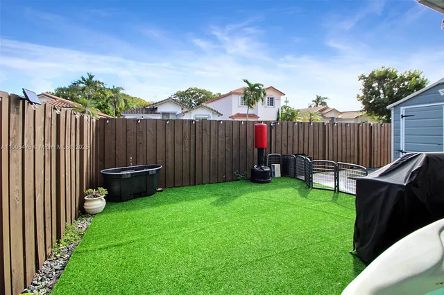a view of backyard with wooden fence
