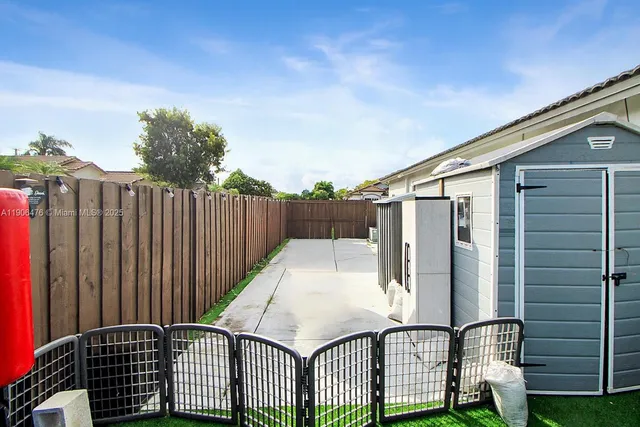 a view of a backyard with wooden fence and floor