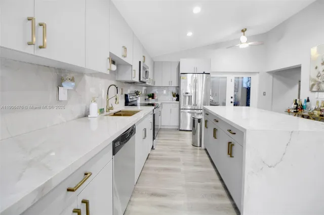 a large kitchen with stainless steel appliances lots of counter space and wooden floor