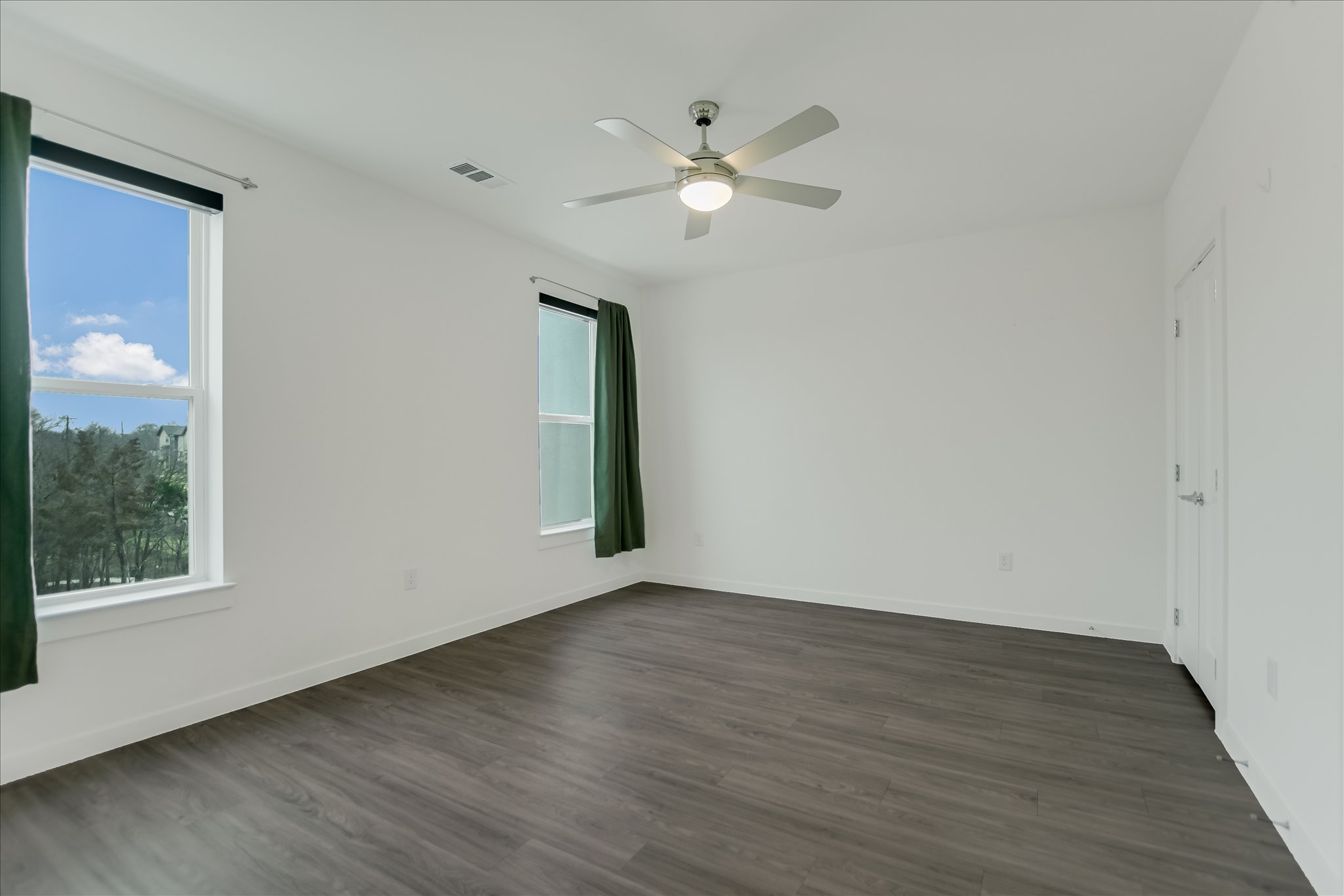4801 Springdale Road, Unit 1207 Austin, TX 78723 - Photo 5 of 10 Unfurnished room featuring dark wood finished floors, healthy amount of natural light, and a ceiling fan