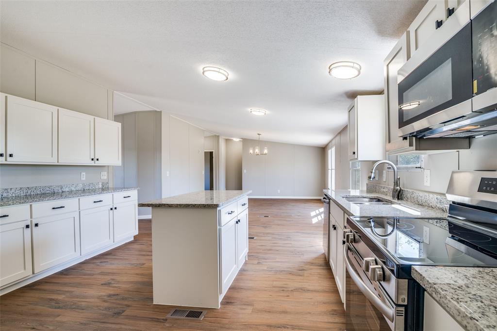 3176 North Ridge Crandall, TX 75114 - Photo 12 of 24 a kitchen with stainless steel appliances granite countertop a sink stove and refrigerator