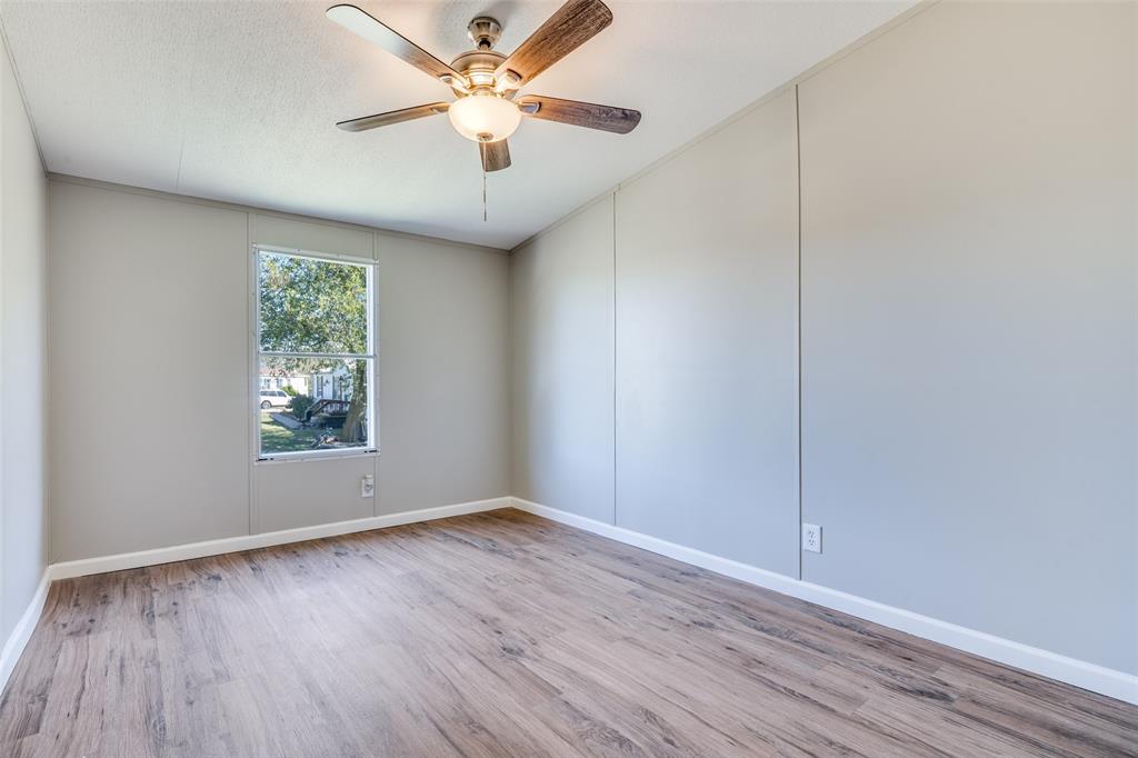 3176 North Ridge Crandall, TX 75114 - Photo 18 of 24 an empty room with wooden floor chandelier fan and windows
