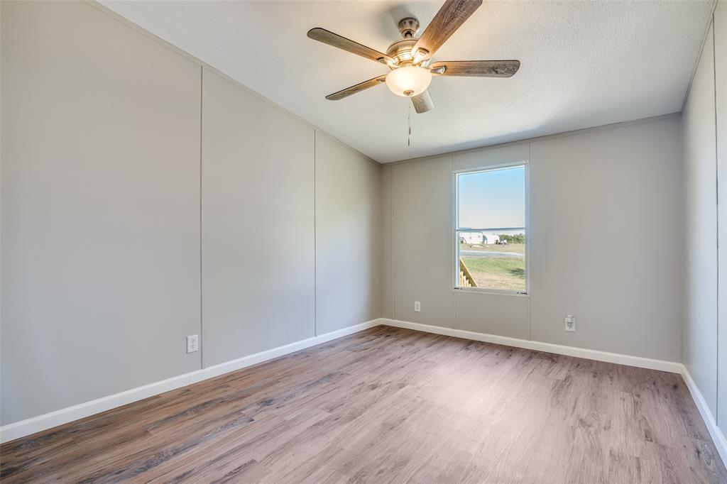 3176 North Ridge Crandall, TX 75114 - Photo 19 of 24 an empty room with wooden floor and windows