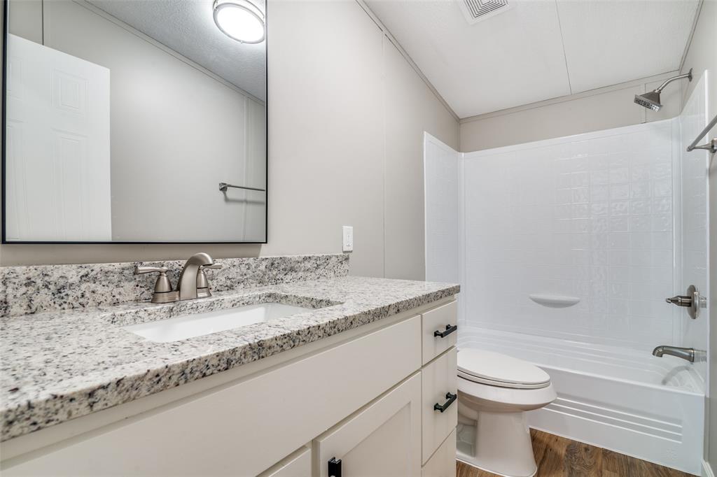 3176 North Ridge Crandall, TX 75114 - Photo 20 of 24 a bathroom with a granite countertop sink a toilet and shower