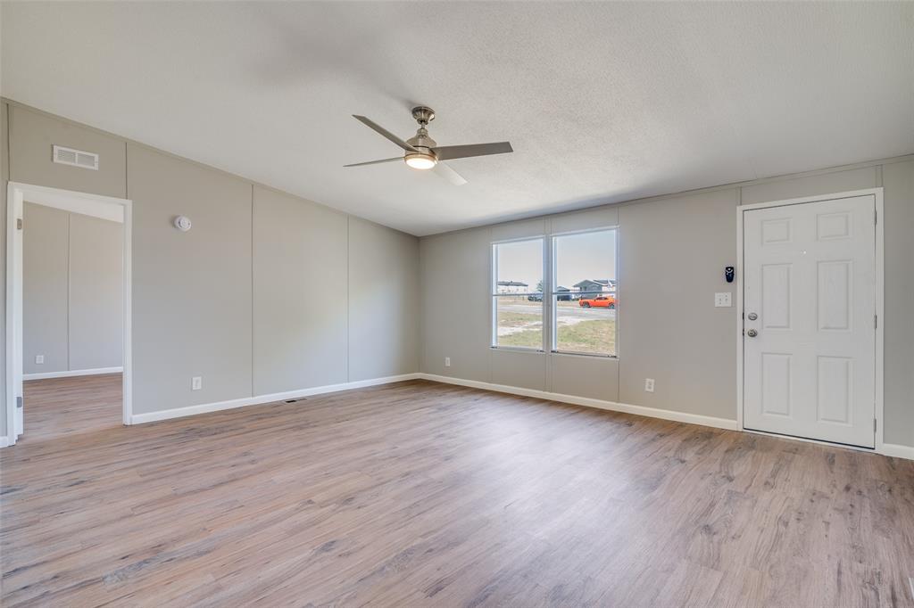 3176 North Ridge Crandall, TX 75114 - Photo 3 of 24 an empty room with wooden floor ceiling fan and windows