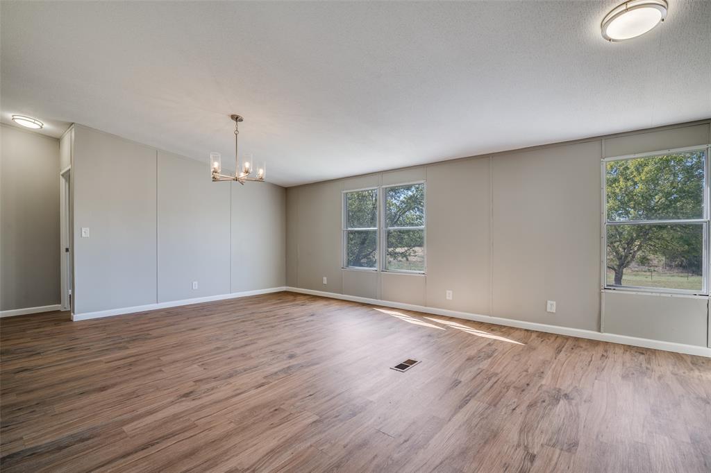 3176 North Ridge Crandall, TX 75114 - Photo 6 of 24 an empty room with wooden floor and windows
