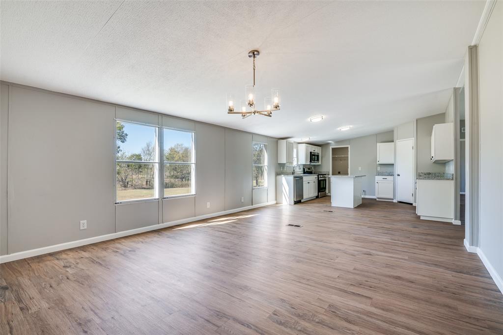 3176 North Ridge Crandall, TX 75114 - Photo 7 of 24 a view of a livingroom with wooden floor and a kitchen space
