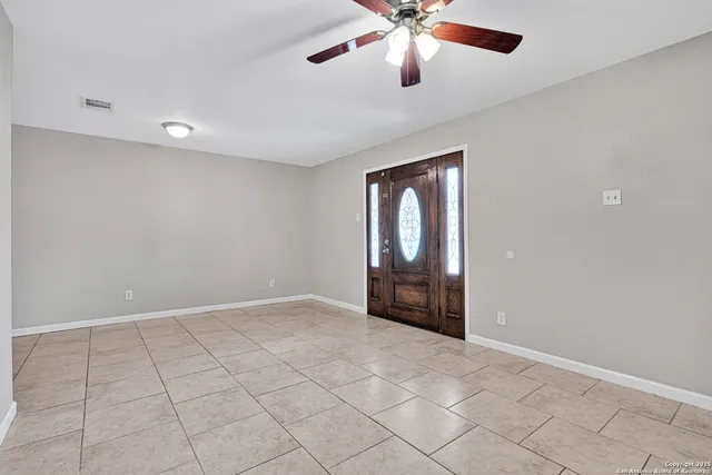 an empty room with windows and fan