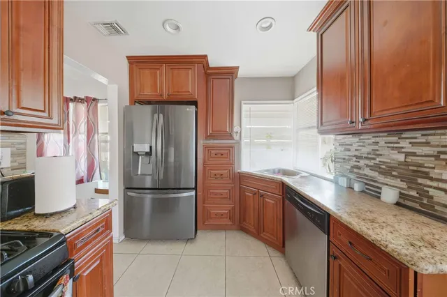 a kitchen with granite countertop a refrigerator stove and sink
